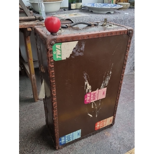 482 - An early 20th century steamer wardrobe trunk. Features metal studs and multiple storage compartments... 