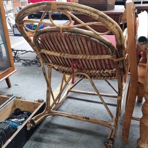 483 - A charming indoor / outdoor Vintage rattan rocking chair with red upholstered cushion.