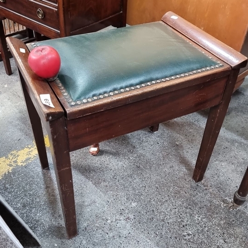 489 - A vintage oak piano stool with green leather seat and internal storage compartment for sheet music.