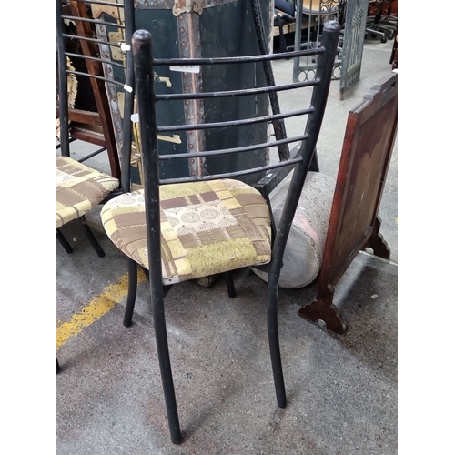 493 - A set of four vintage metal frame chairs with patchwork-patterned cushioned seats. Black frames with... 