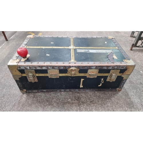 498 - A vintage travel trunk with metal edging and clasps, featuring a black exterior and fabric-lined int... 