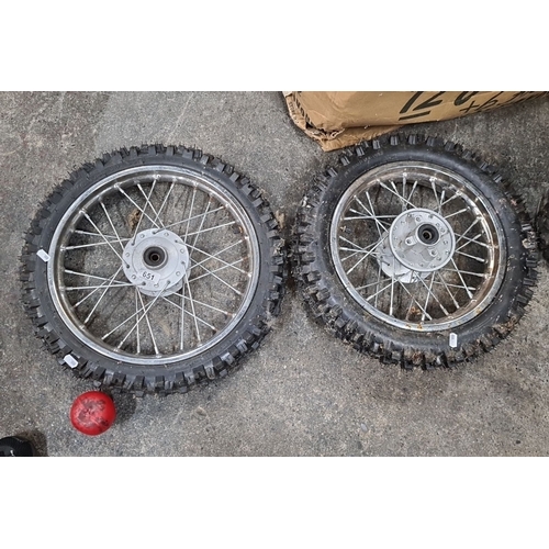 651 - Pair of motocross wheels, featuring 60/100-14 knobby tires with spoke rims.