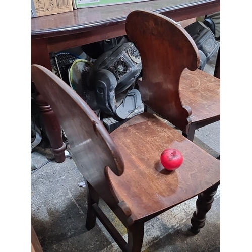 682 - A pair of Victorian hall chairs with shield backs featuring carved designs and lovely turned wood le... 