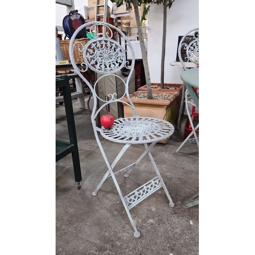 691 - Star lot : A vintage wrought iron garden set including a round table and four intricately designed f... 