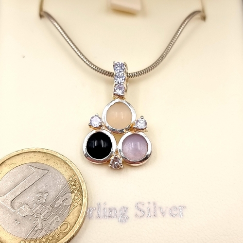 521 - A three stone gem set pendant with sterling silver chain. Length - 44 cms. Boxed.