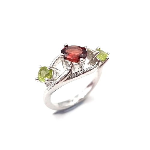 542 - A lovely three stone ring set with garnet & peridot stones. Weight - 5.5 grams. Size - P. Boxed. Set... 