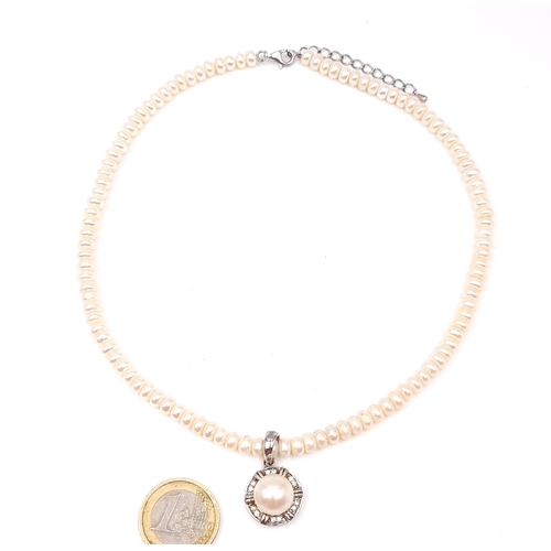 584 - A circular sterling silver pearl and zirconia necklace with adjustable chain. Length - 46 cms. Comes... 