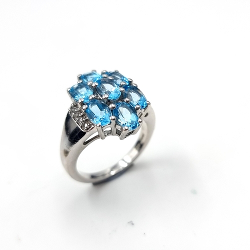 548 - A stunning seven stone blue topaz ring set in sterling silver.. Size - O. Weight - 6.75 grams. Boxed... 