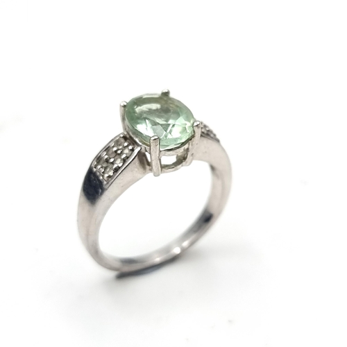 556 - An aquamarine stone ring with gem set surround In sterling Silver.. Ring size - S. Weight - 4.75 gra... 