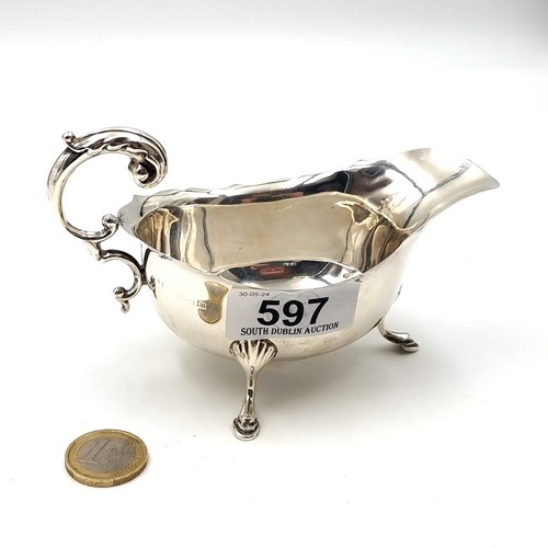 597 - A sterling silver gravy boat hallmarked Birmingham - 1932. Set with a pie crust rim and flying C han... 