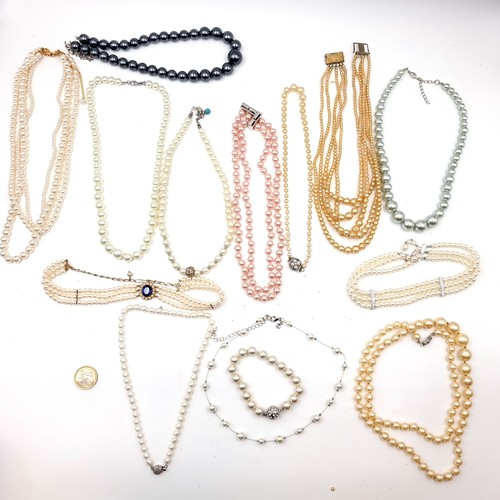 612 - A large collection of assorted 12 pearl necklaces - some multi strand. Together with choker examples... 