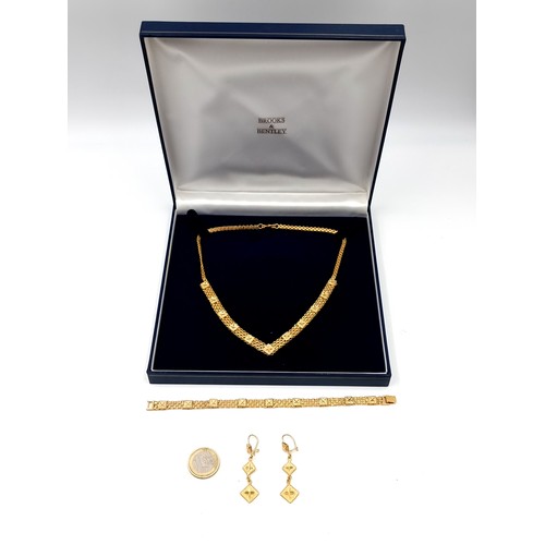 633 - A suite of gold toned jewellery consisting of a necklace. Length - 42 cms. Together with a matching ... 