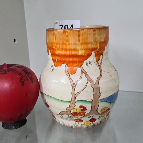 704 - A Clarice Cliff ceramic vase with hand-painted landscape, featuring trees and flowers in vibrant col... 