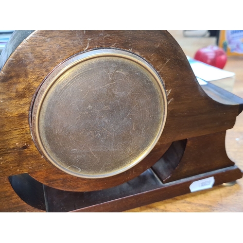 715 - An early twentieth century mahogany mantel clock with brass accents, featuring a domed top and Roman... 