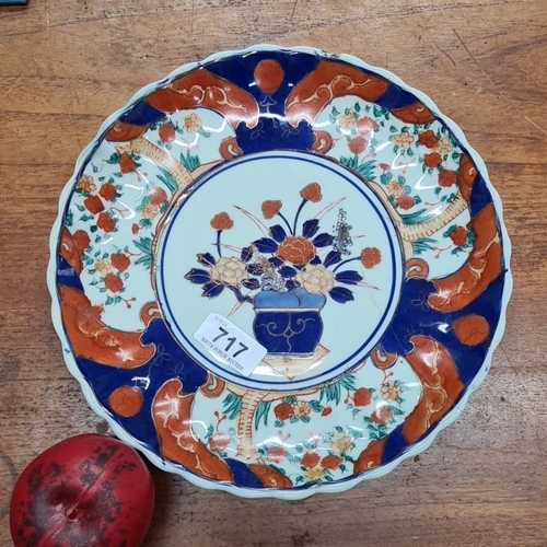 717 - An Imari-style porcelain plate, featuring vibrant floral motifs in cobalt blue, iron red, and touche... 