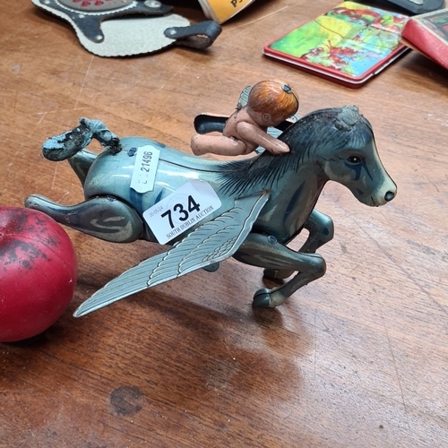 734 - A vintage tin toy figure of a cherub riding Pegasus, produced by Daiya, Made in Japan.