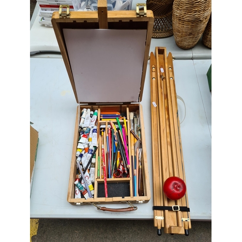 311 - An artists wooden tripod easel stand, along with a table top easel storage tool box containing some ... 