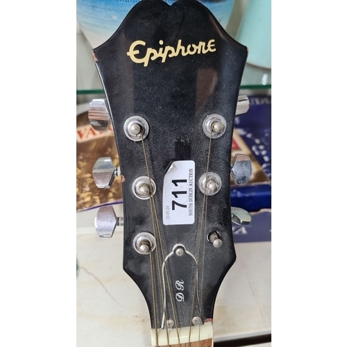 711 - An Epiphone acoustic guitar, black finish, six strings, featuring a spruce top and mahogany body. De... 