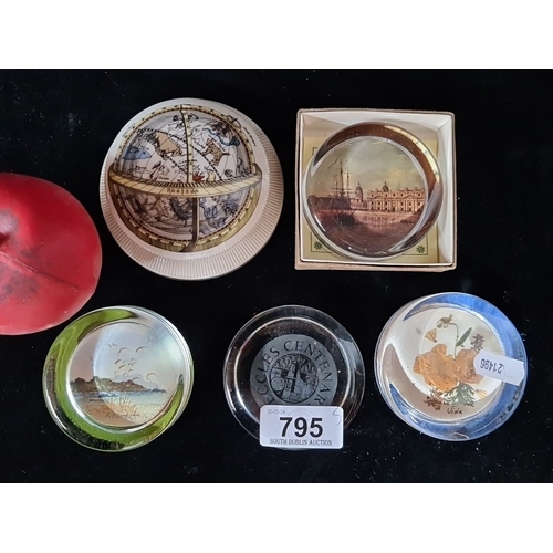 795 - A collection of five decorative paperweights, featuring various designs including landscapes and a c... 