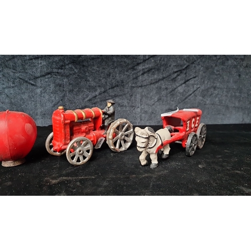 799 - Two vintage cast metal heavy toy vehicles, featuring a red tractor with driver and a red I.C.S. hors... 