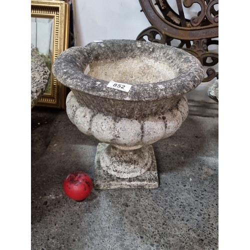 852 - Antique stone garden urn with a weathered patina, featuring a scalloped rim and pedestal base. Ideal... 