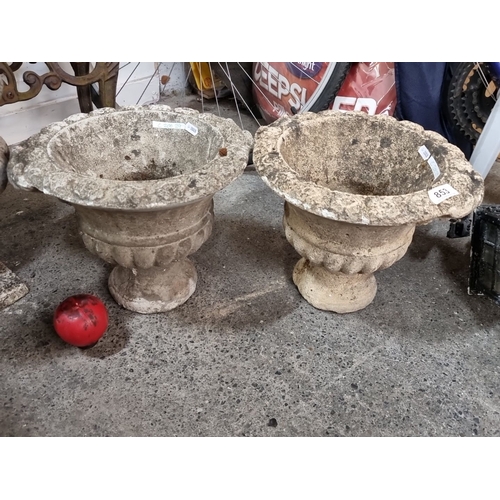 853 - Star Lot : Pair of vintage stone garden urn planters, featuring a classic fluted design with a wide,... 