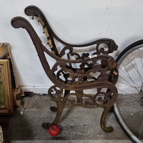 855 - A pair of cast iron bench ends with intricate scrolling design and lion head details.