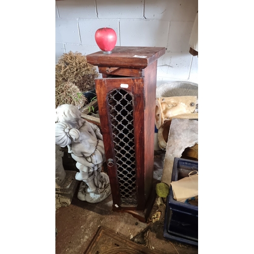 861 - A mahogany spindle-front CD rack. Features an intricately carved door with interior slots designed f... 