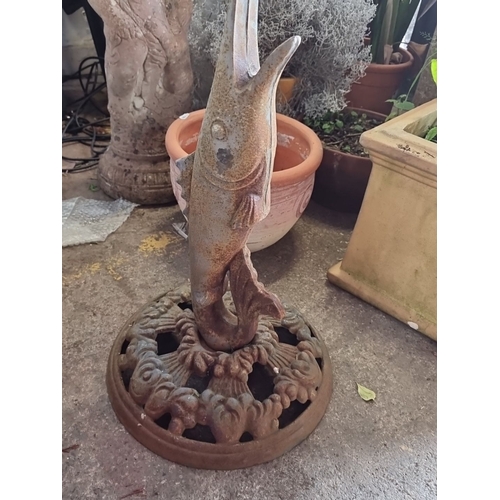 868 - Cast iron birdbath with fish base and scalloped bowl design, featuring aged patina. A charming garde... 