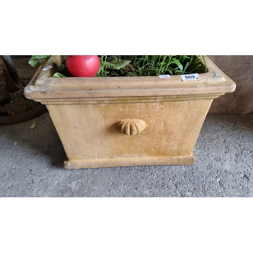 869 - Large ceramic planter with foliage, featuring decorative relief detail on the front. Includes a smal... 