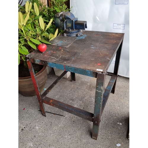 872 - Heavy-duty wood topped metal workbench with an integrated blue steel bench vise. Vise features a 125... 