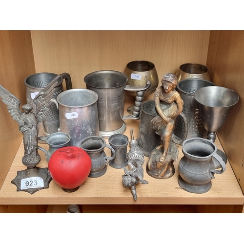 923 - A large quantity of pewter items consisting of tankards, goblets, and two ornaments.