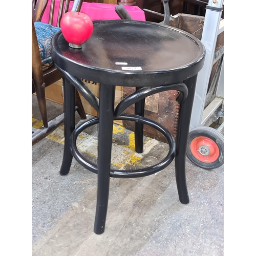 957 - A nice sturdy bentwood stool in a black finish with an integrated foot rest.