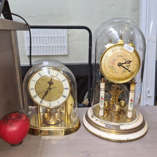 967 - Two very pretty torsion pendulum mantel clocks with glass dome tops. One Hettich and one Hallers exa... 