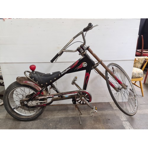 664 - A Schwinn stingray chopper bike with leather saddle, featuring red and black flame graphics and a si... 