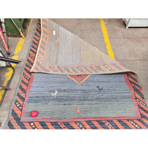 295 - A lovely large  rug featuring animal and geometric design. In tones of blue, green and orange. MM 22... 