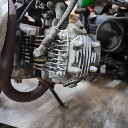 650 - Star Lot: Kawasaki dirt bike with green body and Monster Energy branding. Engine close-up detailing ... 