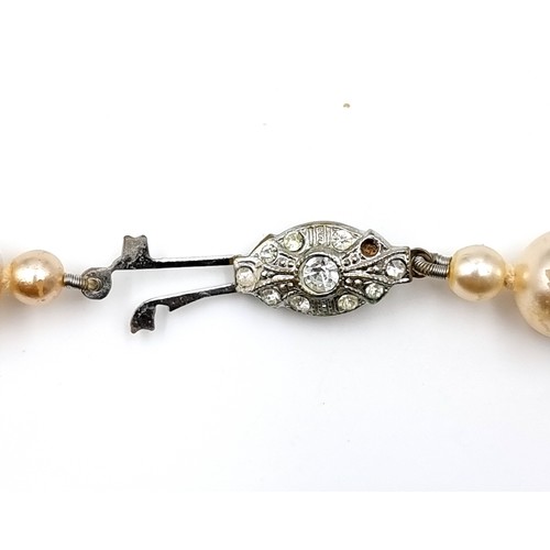 8 - A pearl necklace set with gem set clasp. Length of necklace - 68 cms. Weight - 80 grams. Contained i... 