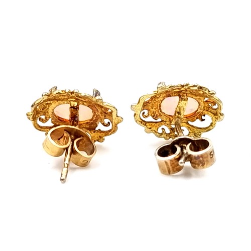 26 - A pair of fire opal stud earrings set in nine carat gold with attractive filigree mount. Total weigh... 