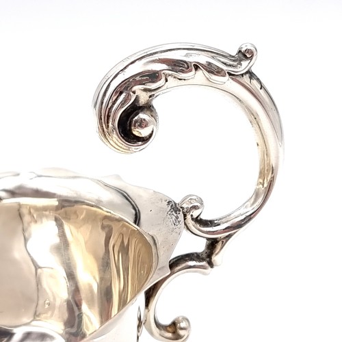 597 - A sterling silver gravy boat hallmarked Birmingham - 1932. Set with a pie crust rim and flying C han... 