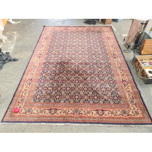 845 - STAR LOT : A Persian hand-knotted wool rug featuring intricate floral motifs and vibrant geometric b... 