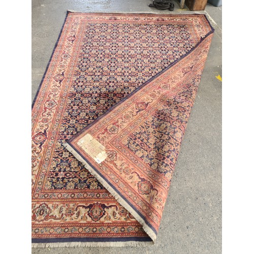 845 - STAR LOT : A Persian hand-knotted wool rug featuring intricate floral motifs and vibrant geometric b... 