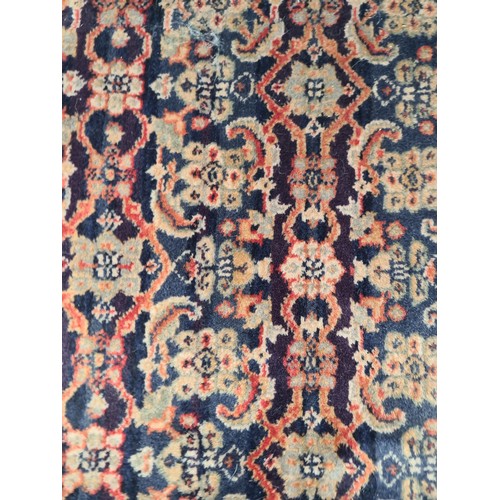 845 - STAR LOT : A Persian hand-knotted wool rug featuring intricate floral motifs and vibrant geometric b... 