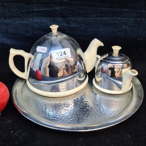 124 - A lovely mid century modern stay hot set of two teapots resting on a hammered effect finish silver t... 