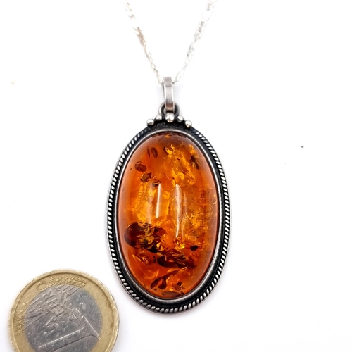 25 - An antique oval amber pendant & chain set in sterling silver. Length of chain - 76 cms. Stone - 4 x ... 