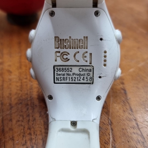 A Bushnell Neo XS Golf GPS Watch in white with charging cable. Model ...