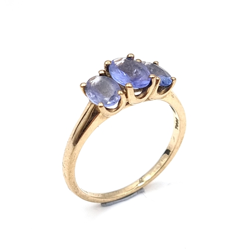 937 - Star Lot : A nine carat gold (375) three stone Tanzanite ring. Ring size - O. Weight - 2.08 grams. B... 