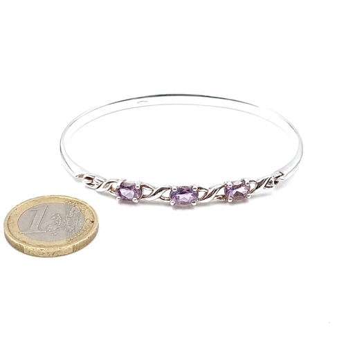 957 - A sterling silver twist set three stone amethyst bracelet. Weight - 11.36 grams.