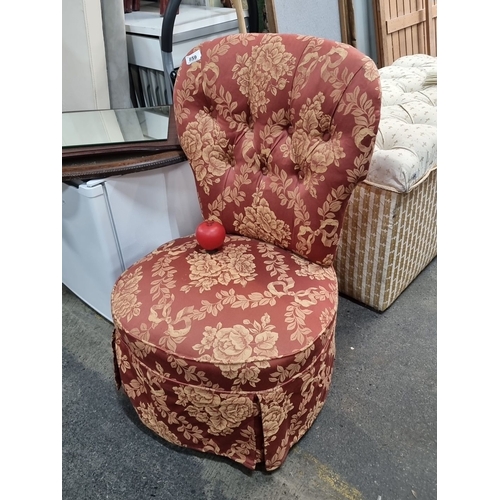 859 - Upholstered mauve floral slipper chair with tufted backrest. The chair features a pleated skirt and ... 