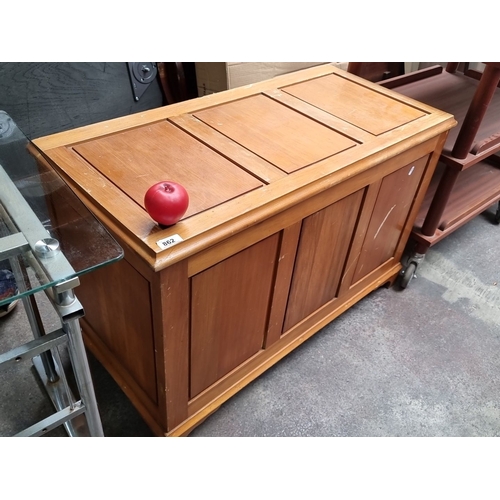 862 - A solid wood storage chest with hinged top lid. Pine construction with traditional paneling and natu... 